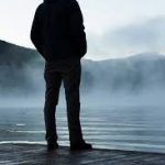 image of man looking out over lake